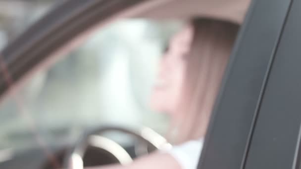 Menina bonita sentada no carro mostrando carta de condução novo motorista — Vídeo de Stock