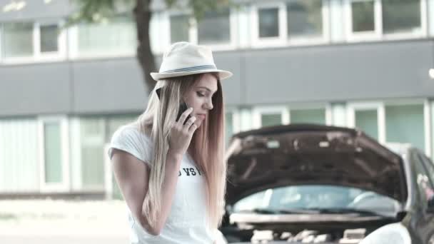 Mujer joven con un coche roto pidiendo ayuda — Vídeos de Stock