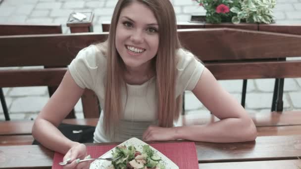 Mujer comiendo en el restaurante y hablando por teléfono en la ciudad — Vídeos de Stock