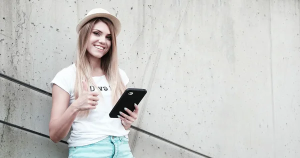 Menina com polegares para cima usando um tablet — Fotografia de Stock