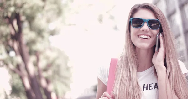 Mujer joven en traje de moda sonriendo mientras está en el teléfono — Foto de Stock