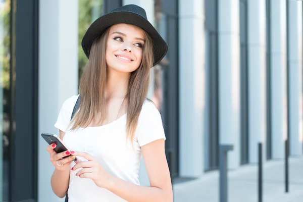 Atraktivní žena s úsměvem telefon a do vzdálenosti — Stock fotografie