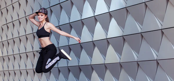 Танцы хип-хоп в воздухе на фоне стены — стоковое фото