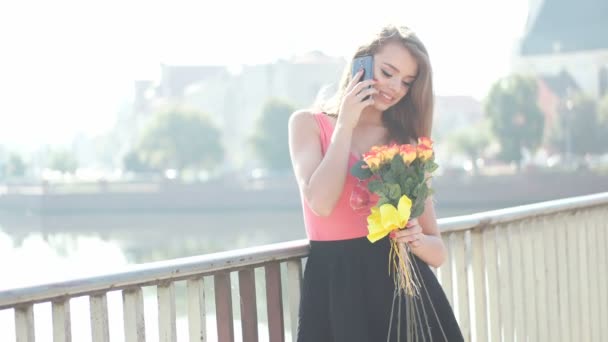 Tonåring promenader med en massa blommor i staden — Stockvideo