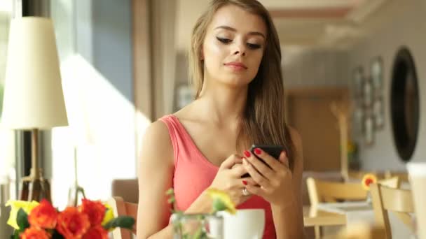 Mujer en la cafetería bebiendo capuchino y enviando mensaje de texto — Vídeos de Stock