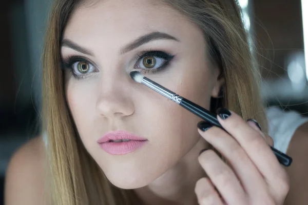 Primer plano de la mujer que aplica maquillaje — Foto de Stock