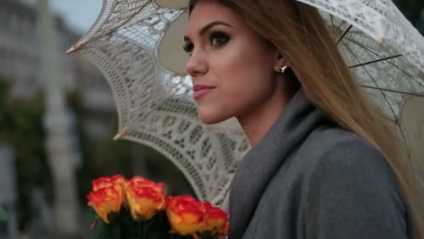Блондинка тримає купу троянд в дощовий день — стокове відео