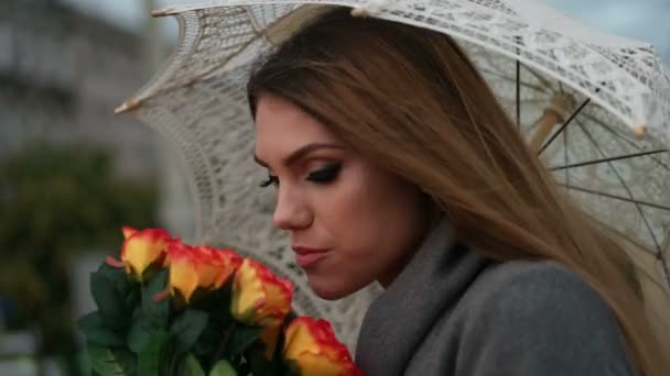 Femme blonde tenant un bouquet de roses dans un jour de pluie — Video