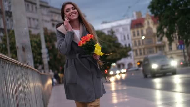 Vrouw snuiven bloemen terwijl het spreken over de telefoon, de dag van Valentijnskaarten concept — Stockvideo