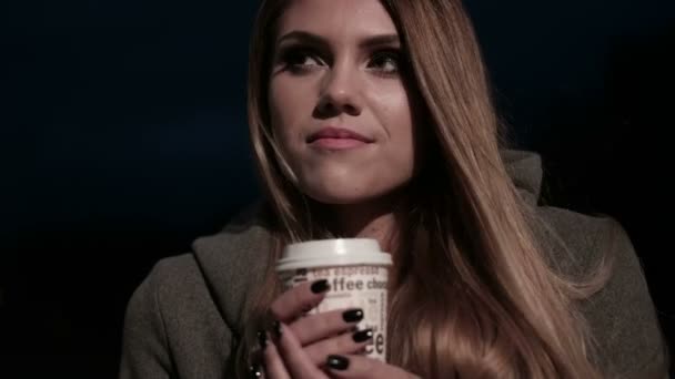Tinédzser lány az utcán éjjel, ivott kávét, és várja — Stock videók