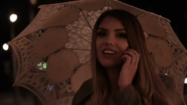 Jovem mulher feliz ter conversa telefone emocionante segurando guarda-chuva no dia chuvoso — Vídeo de Stock