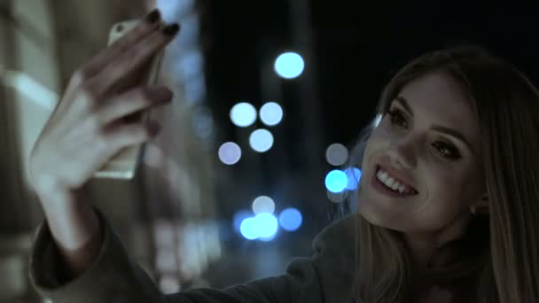 Щаслива жінка бере селфі по телефону йде вечірній час — стокове відео