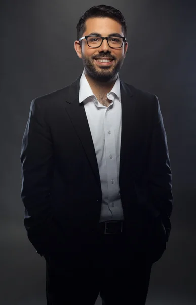 Joven hombre guapo en traje negro y gafas — Foto de Stock