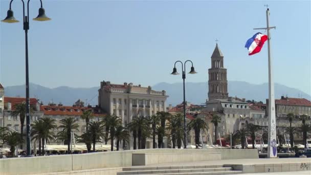 克罗地亚斯普利特市的长廊 以圣多姆尼乌斯钟塔和旧城分裂为背景的分裂长廊上的克罗地亚国旗 — 图库视频影像