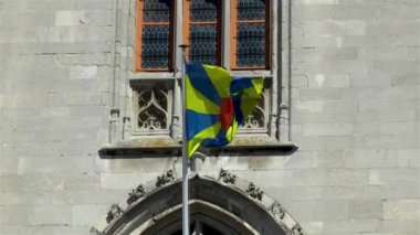 Batı Flanders bayrağı, Bruges, Belçika 'daki İl Mahkemesi binasına el sallıyor..