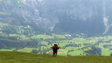 Paraglider ilk dağdan havalanıyor ve İsviçre 'deki Lauterbrunnen Vadisi' nin üzerinden uçuyor..