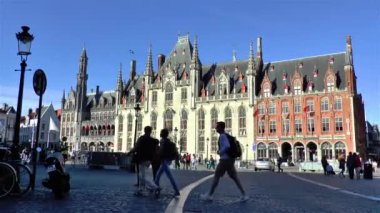 Tourists gather at the popular Markt Square in Bruges, Belgium, where the Provincial Court building stands since medieval times.