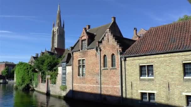 Traditionele Huizen Aan Een Kanaal Met Onze Lieve Vrouwekerk Brugge — Stockvideo