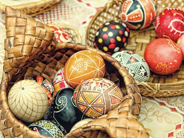 Multicolored easter eggs in straw pot. — Stock Photo, Image