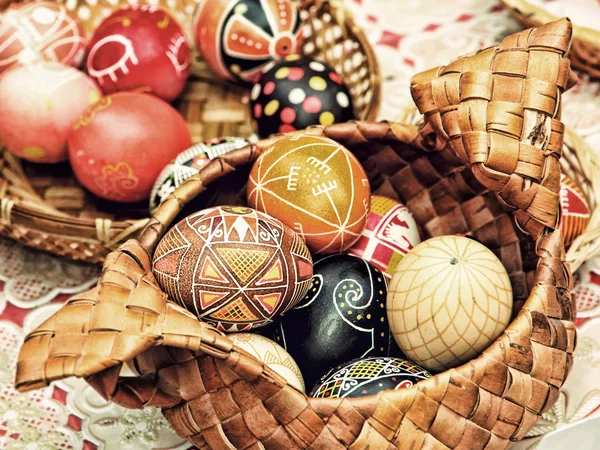 Multicolored easter eggs in straw pot taken closeup. — Stock Photo, Image