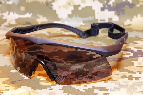 Óculos táticos militares em fundo de camuflagem tomadas close-up — Fotografia de Stock