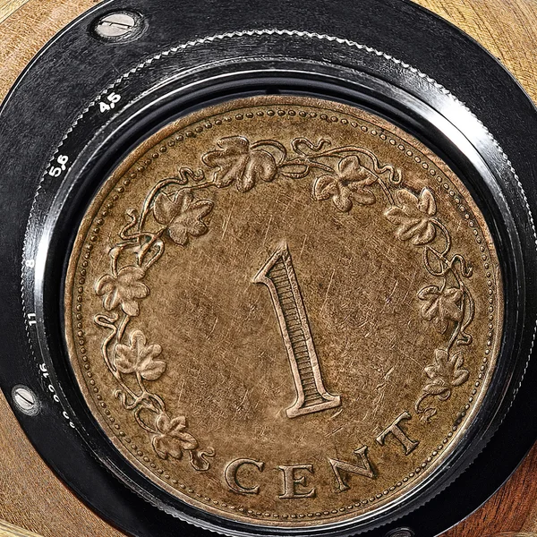 One cent coin inside retro camera lens. — Stock Photo, Image