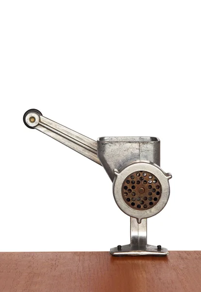 Manual meat mincer on wooden table and white background. — Stock Photo, Image