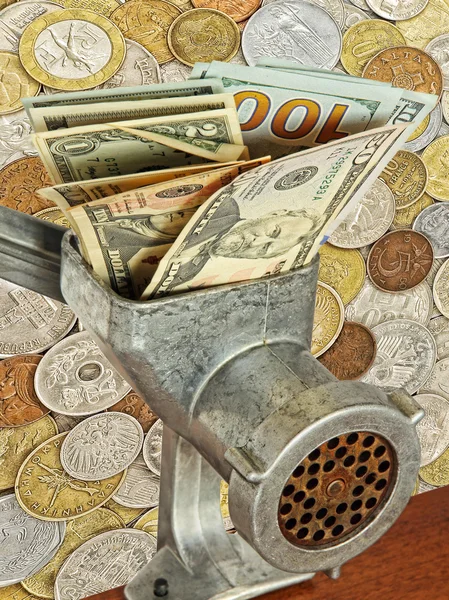 Dollar banknotes in meat grinder on lot of different coins backg — Stock Photo, Image