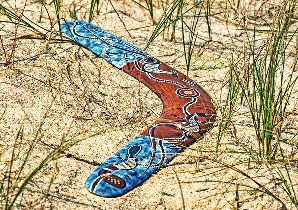 Couleur Boomerang sur le sable parmi une herbe prise gros plan . — Photo