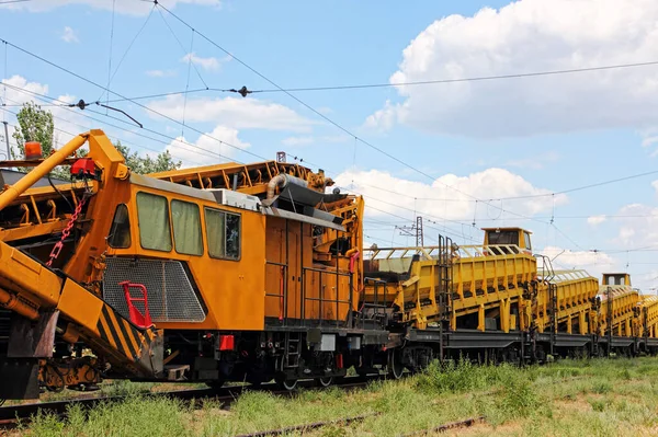 オレンジ鉄道軌道サービス車 レール上の砕石設置工事機械 — ストック写真