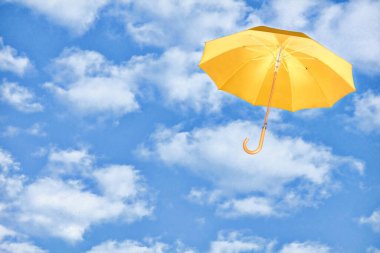 Mary Poppins Şemsiyesi. Sarı şemsiye beyaz bulutlara karşı gökyüzünde uçar. Değişim konsepti rüzgarı..