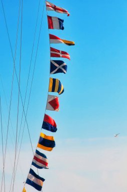 Deniz sinyal bayrakları mavi gökyüzünün direğine dikilmiş, yakından çekilmiş..
