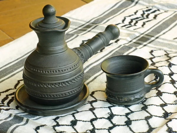Kaffeekanne und Tasse aus Keramik auf einem weißen Keffiyah-Schal. — Stockfoto