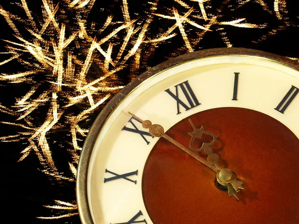 Inför nya year.clock ansikte och gyllene fyrverkeri. — Stockfoto