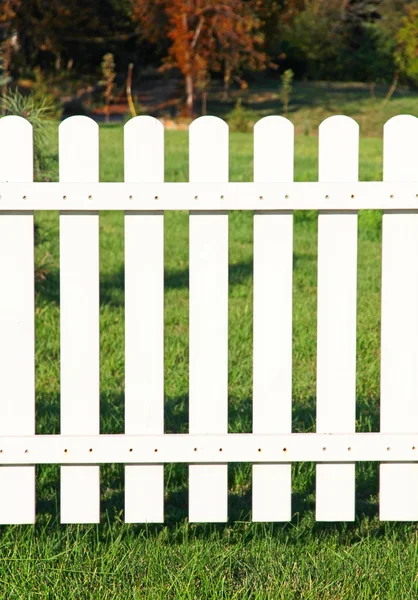 Weißer Zaun auf grünem Gras. — Stockfoto