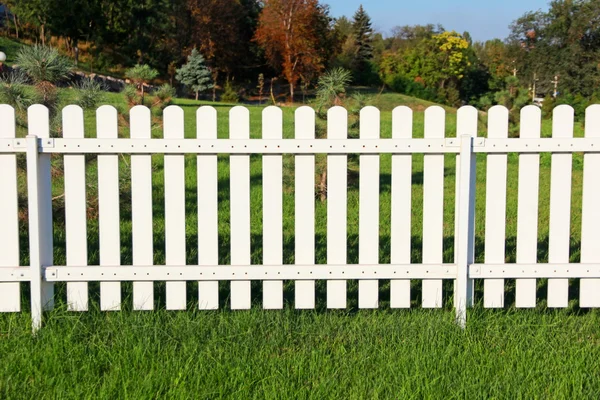 White fence on green grass.