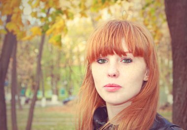 Kırmızı saçlı kız kameraya benziyor. Tonal düzeltme.