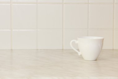 Seramik çay bardağı beyaz mutfak masasında.