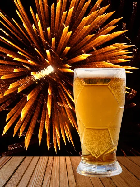 Copo de cerveja em mesa de madeira contra fogos de artifício dourados . Fotos De Bancos De Imagens Sem Royalties