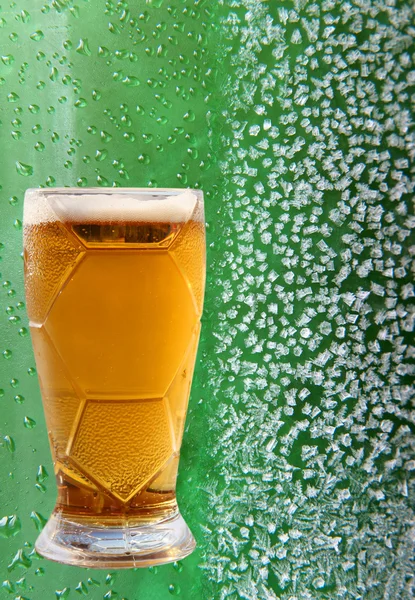 Verre à bière sur cristaux de glace et fond vert goutte à goutte . — Photo