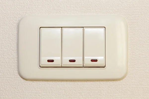 Interruptor de luz triple multiplicar en la pared beige . —  Fotos de Stock