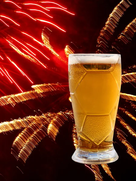 Vaso de cerveza sobre fondo de fuegos artificiales multicolores . —  Fotos de Stock