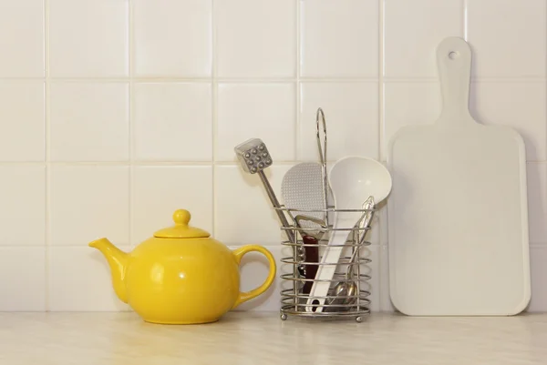 Žlutá keramická konvice a kuchyňské nádobí. — Stock fotografie