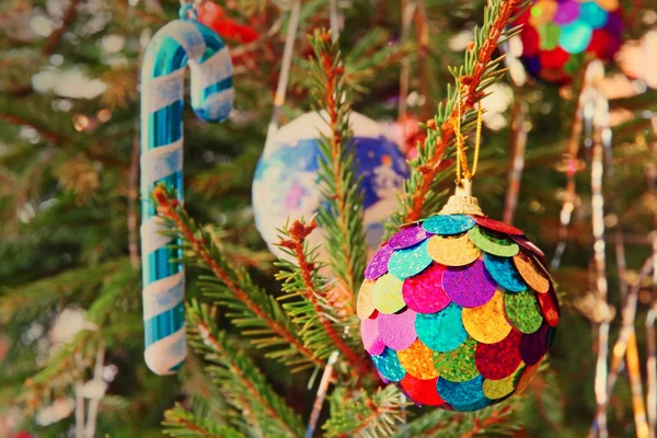 Bola de Natal multicolorida em um ramo de pinho tomado close-up . — Fotografia de Stock