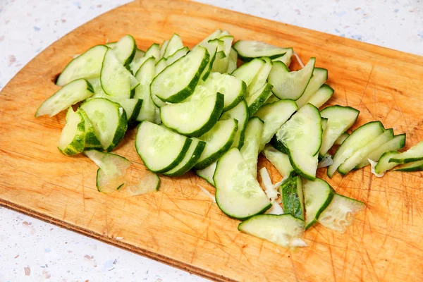 Fresh sliced cucumber on wooden cutting board. — Stock Photo, Image