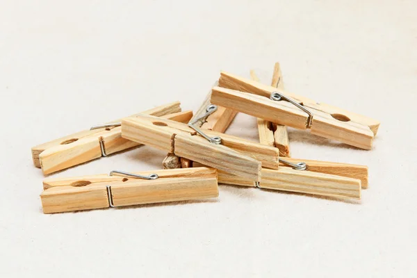 Hromada dřevěných clothespins na pozadí bílé tkaniny. — Stock fotografie