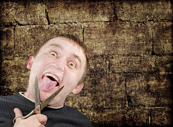 Mad man with scissors cuts off itself tongue on grunge backgroun — Stock Photo, Image