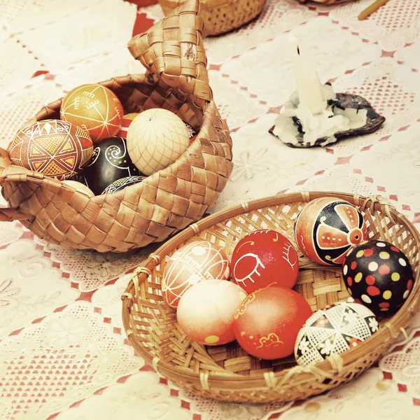 Multicolored easter eggs in straw pots. — Stock Photo, Image