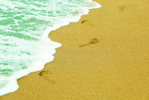 Emberi nyomait a tenger közelében fekvő homokos strandon szörf. — Stock Fotó
