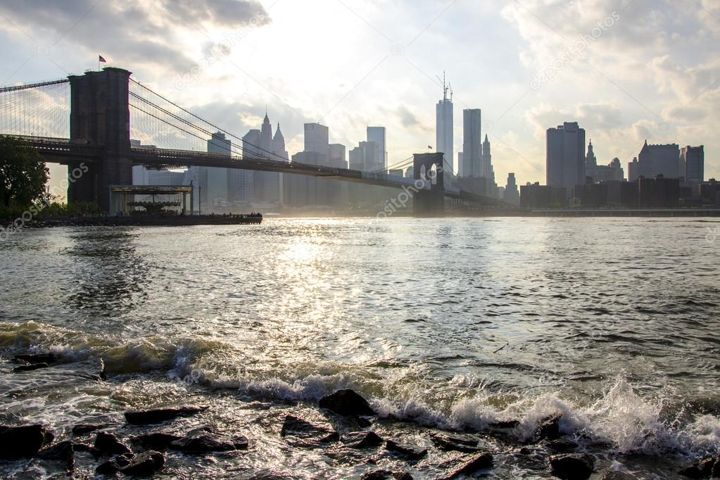 Manhattan skyline and Brooklyn bridge. East river waves. New York City. United States of America.